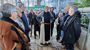 Broeder Isaac, Prior van Abdij Koningshoeven, legt de werking uit van de biologische waterzuiveringsinstallatie. Deze zuivert al heet water, van de Abdij en van de trappistenbierbrouwerij die in de abdij gevestigd is.
